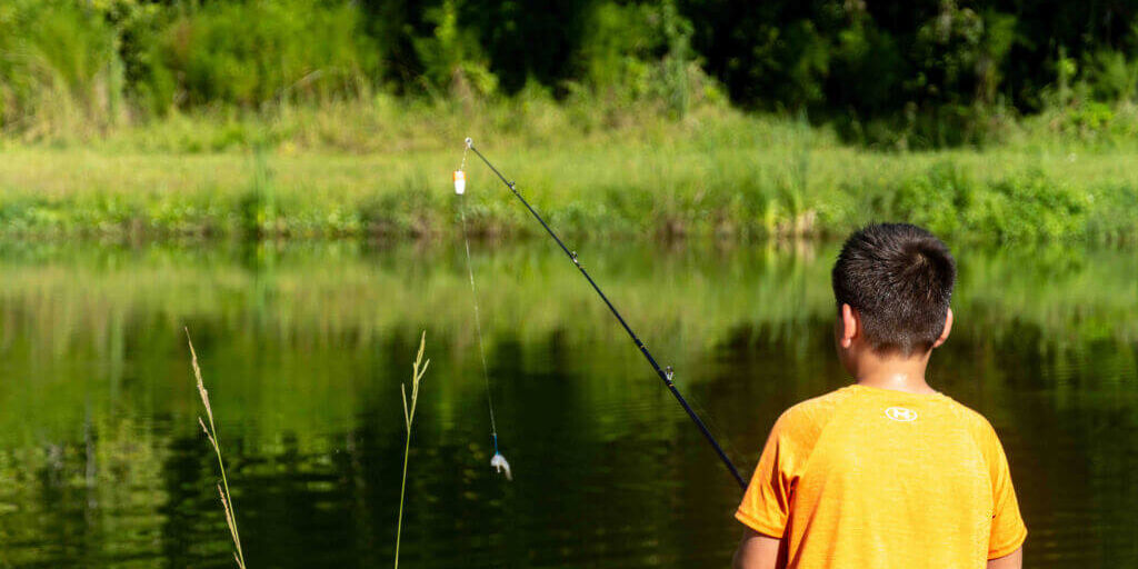 child in orange shirt fishing_Welaka National Fish Hatchery pond__Putnam County_Brandy Jo Hastings (1 of 1) child in orange shirt fishing_Welaka National Fish Hatchery pond__Putnam County_Brandy Jo Hastings
